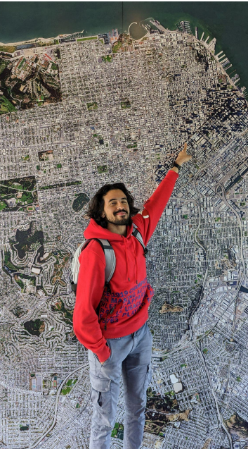 A student pointing at a large aerial map mounted on a wall