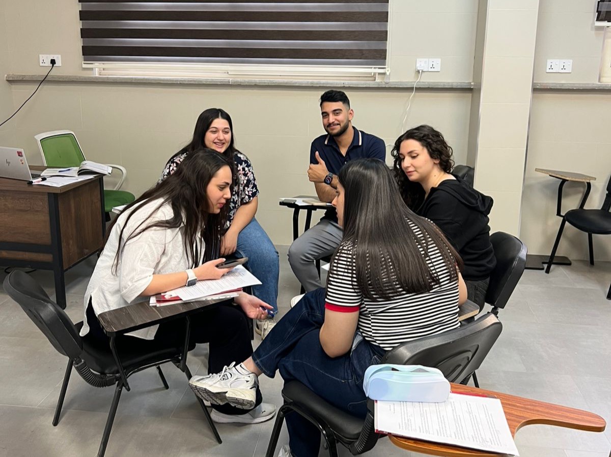 Five English language students in a classroom in Erbil, Iraq, one giving a thumbs up