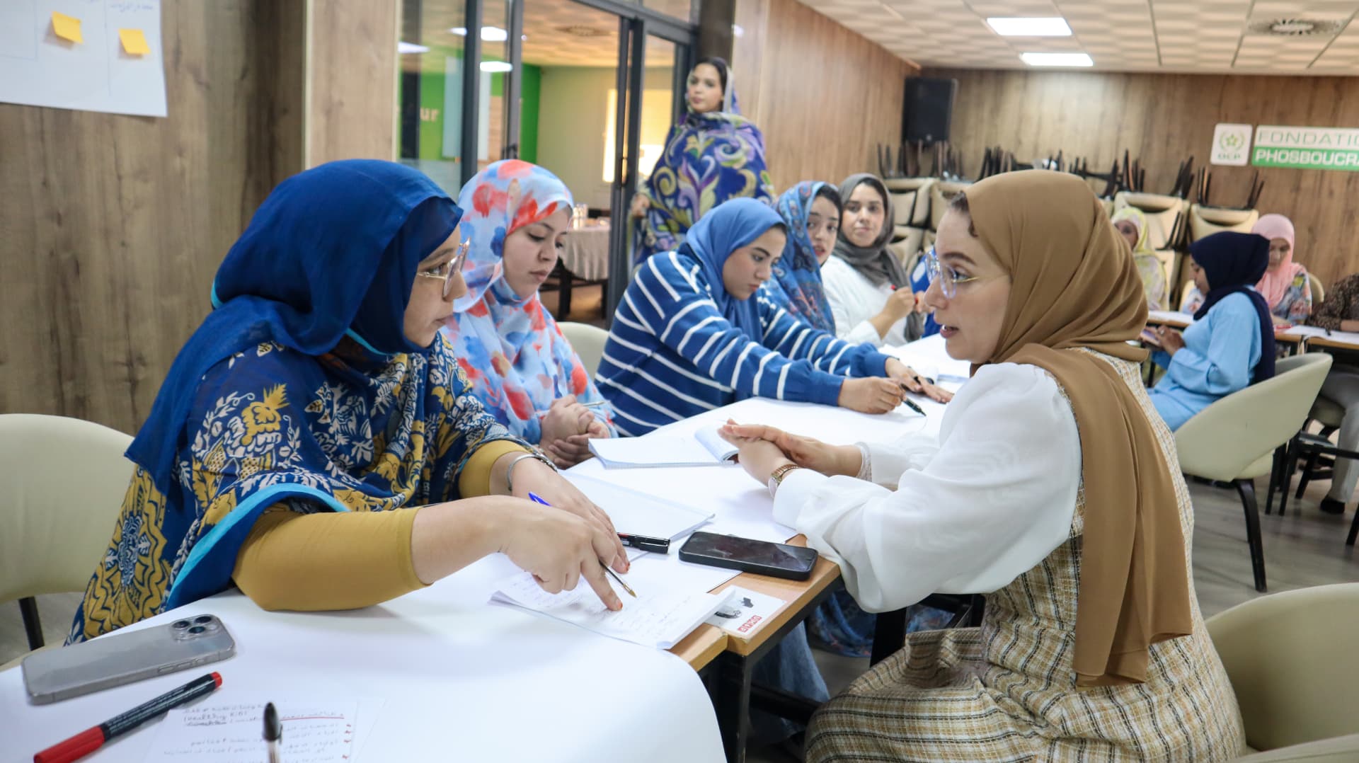 Women seated along a long table during a professional training workshop